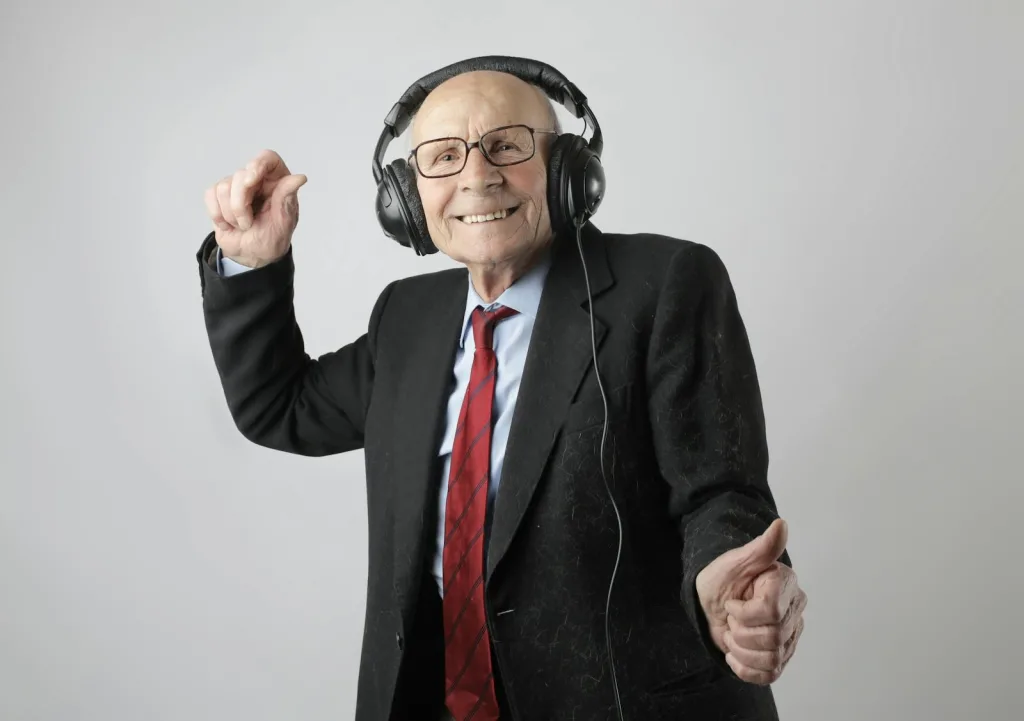 Cheerful elderly man listening to music in headphones