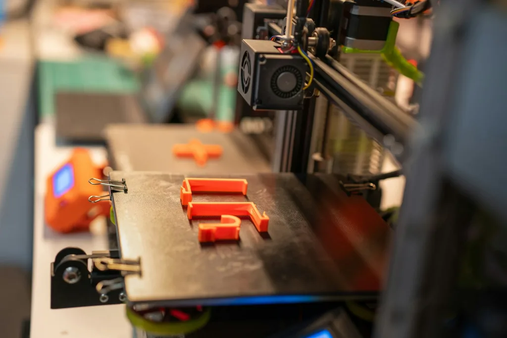 a close up of a machine with orange pieces on it